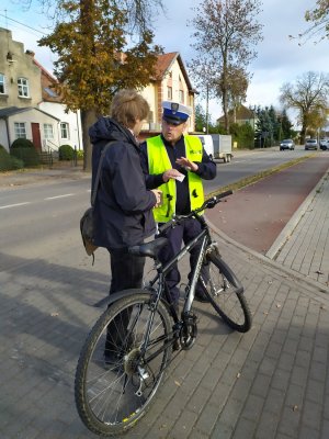 policjant rozdający latarki