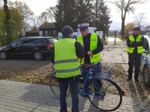 policjant rozdający latarki
