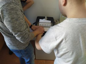funkcjonariusz pobierający odciski palców od zatrzymanego