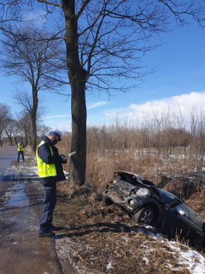 Policjant sporządzający oględziny pojazdu, który wjechał do rowu